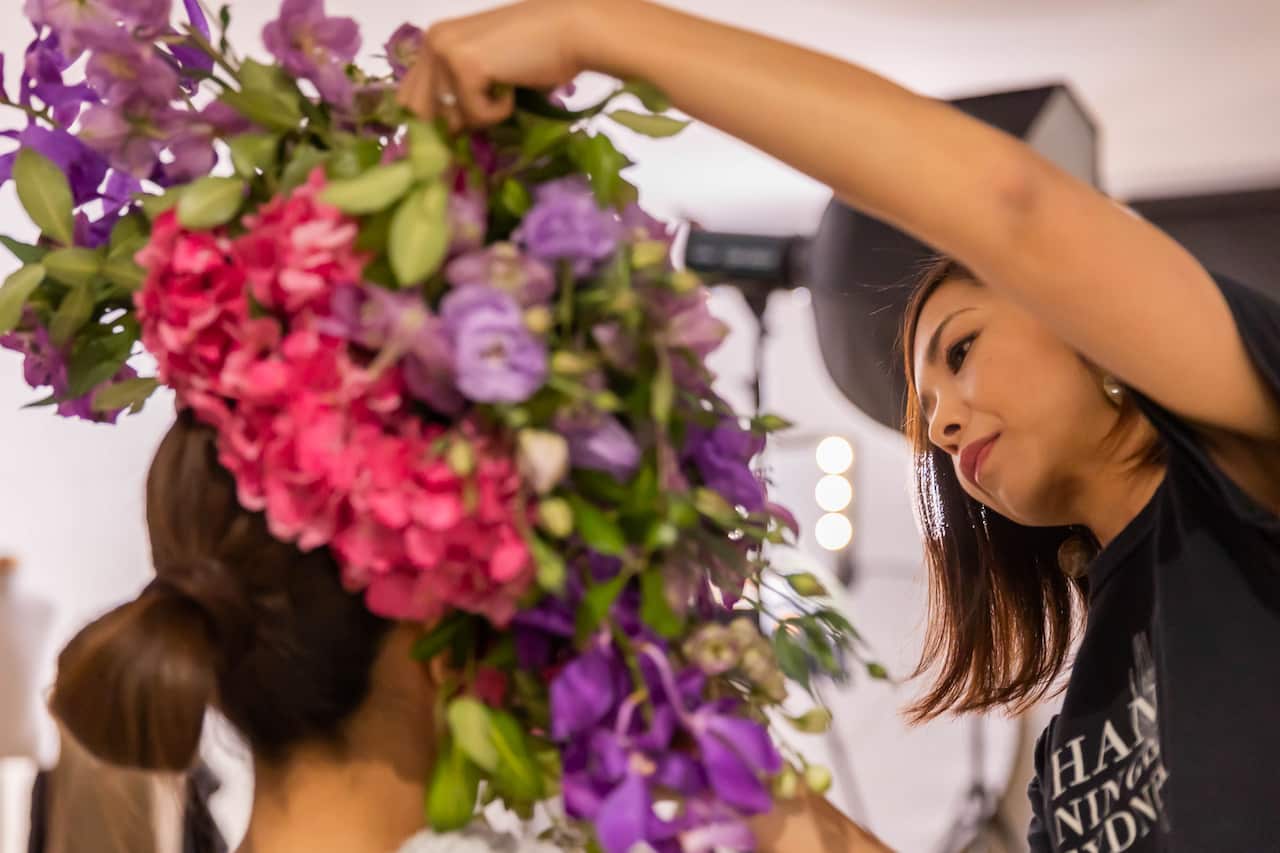 Yuka arranges fresh flowers on people's heads to create "hananingen" or human flower