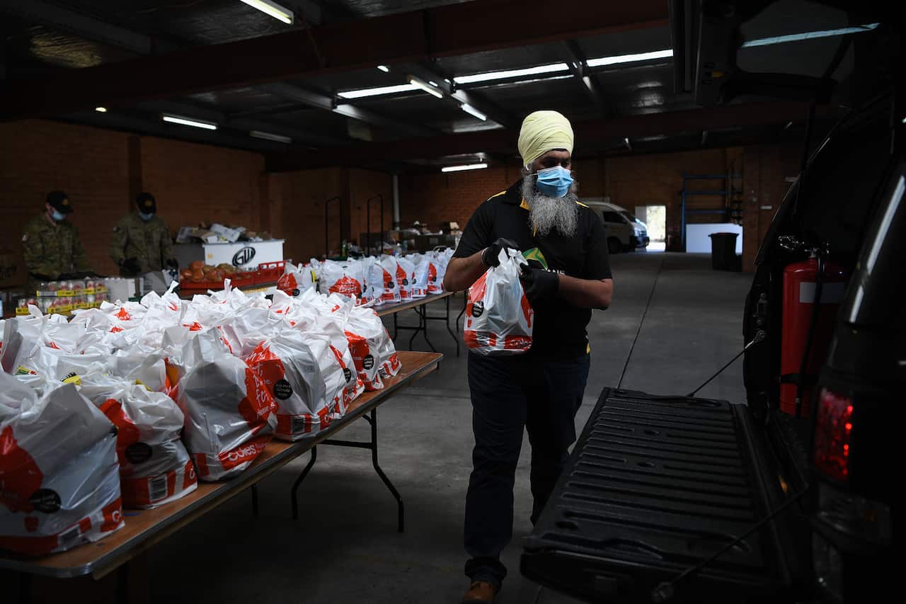 A man loads parcels into a car. 
