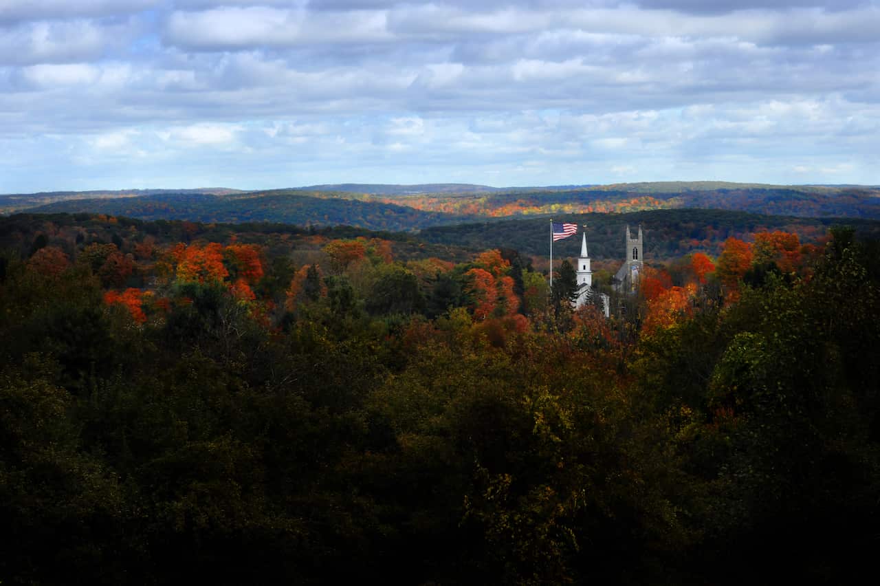 A photo of a small American town surrounded by trees in autumn.