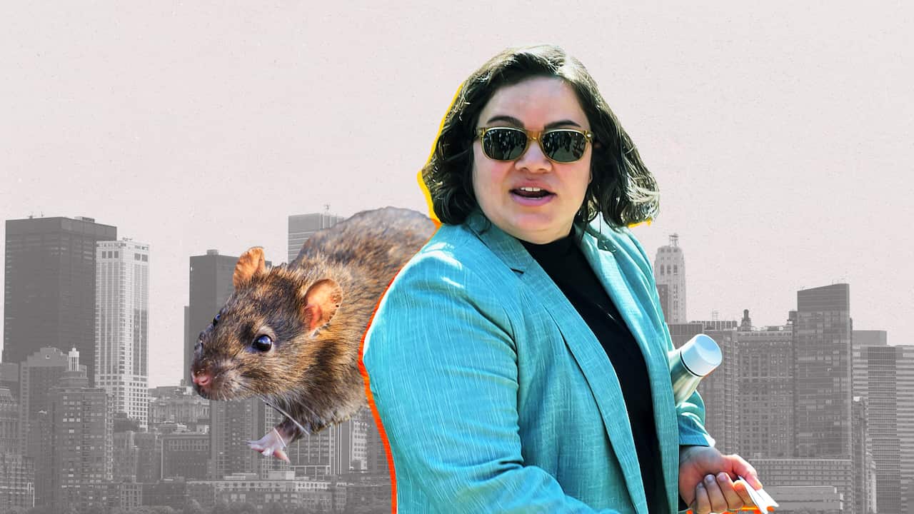 A woman in a blue jacket and a rat to the right. 