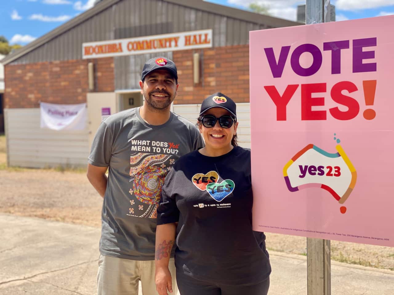 Signatories to the Uluṟu Statement Melissa Clarke and Arrin Hazelbane stand in front of the Koonibba Community Hall next to a sign that reads "Vote Yes!"