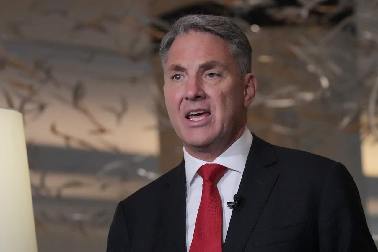 Richard Marles in a suit and red tie, with a lapel mic, speaking.