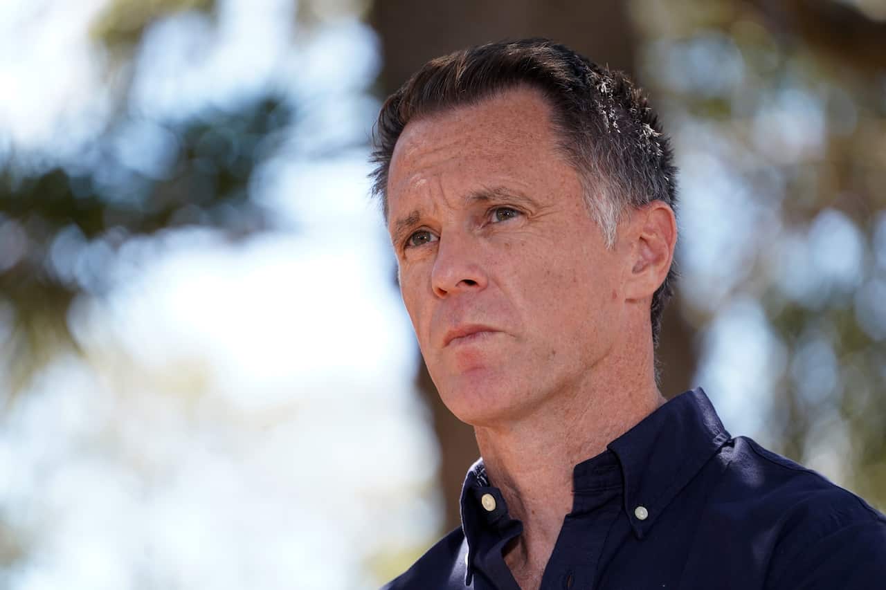 Chris Minns, wearing a blue shirt, staring off into the distance.