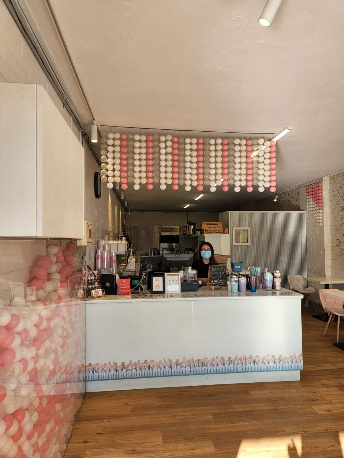 Woman standing inside a bubble tea shop.
