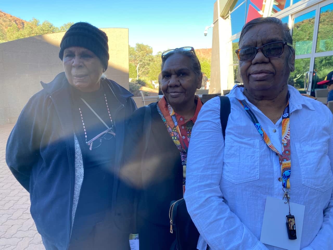 Three women stand for a photo. 