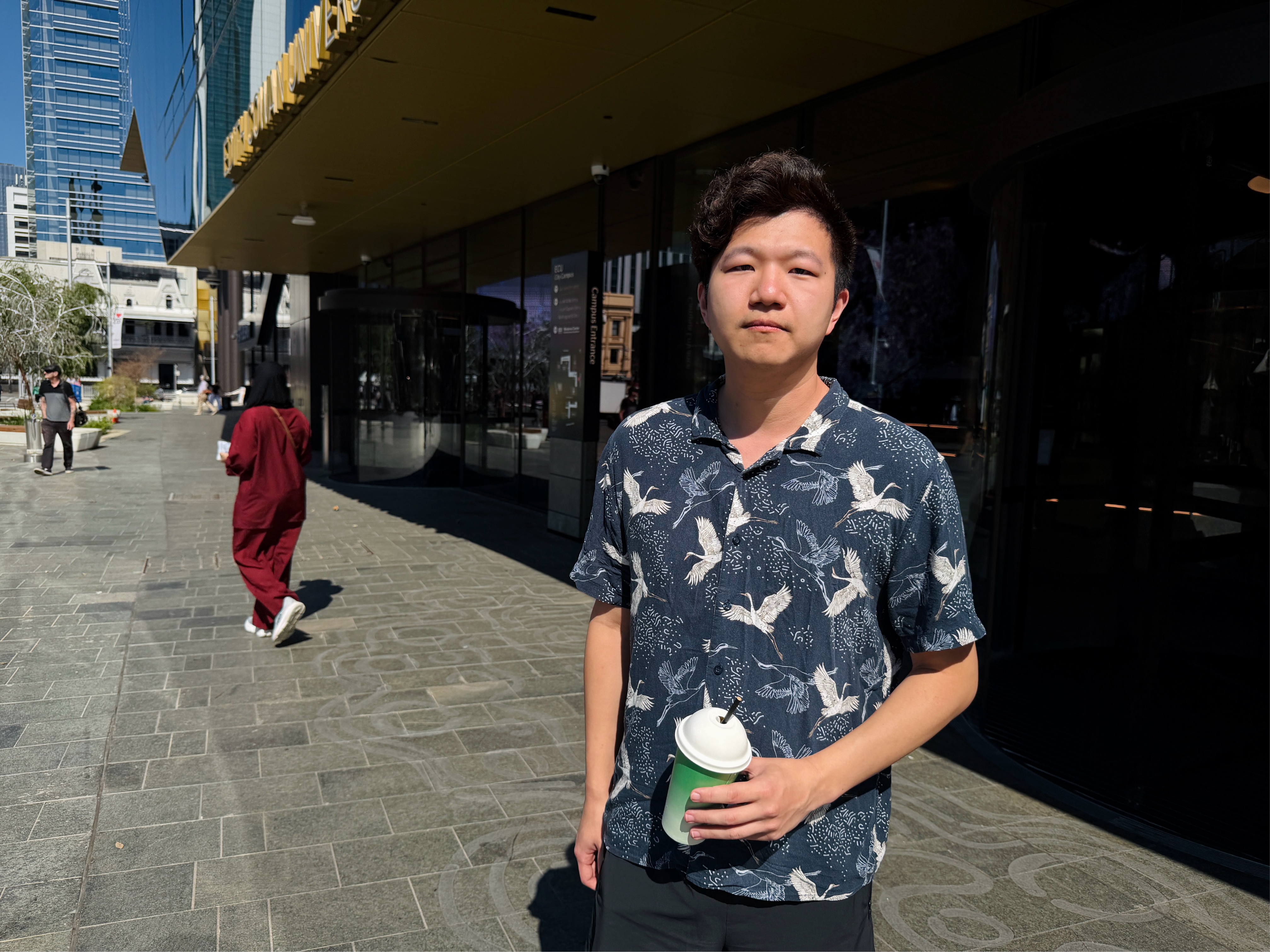 A man poses for a photo on a city street.