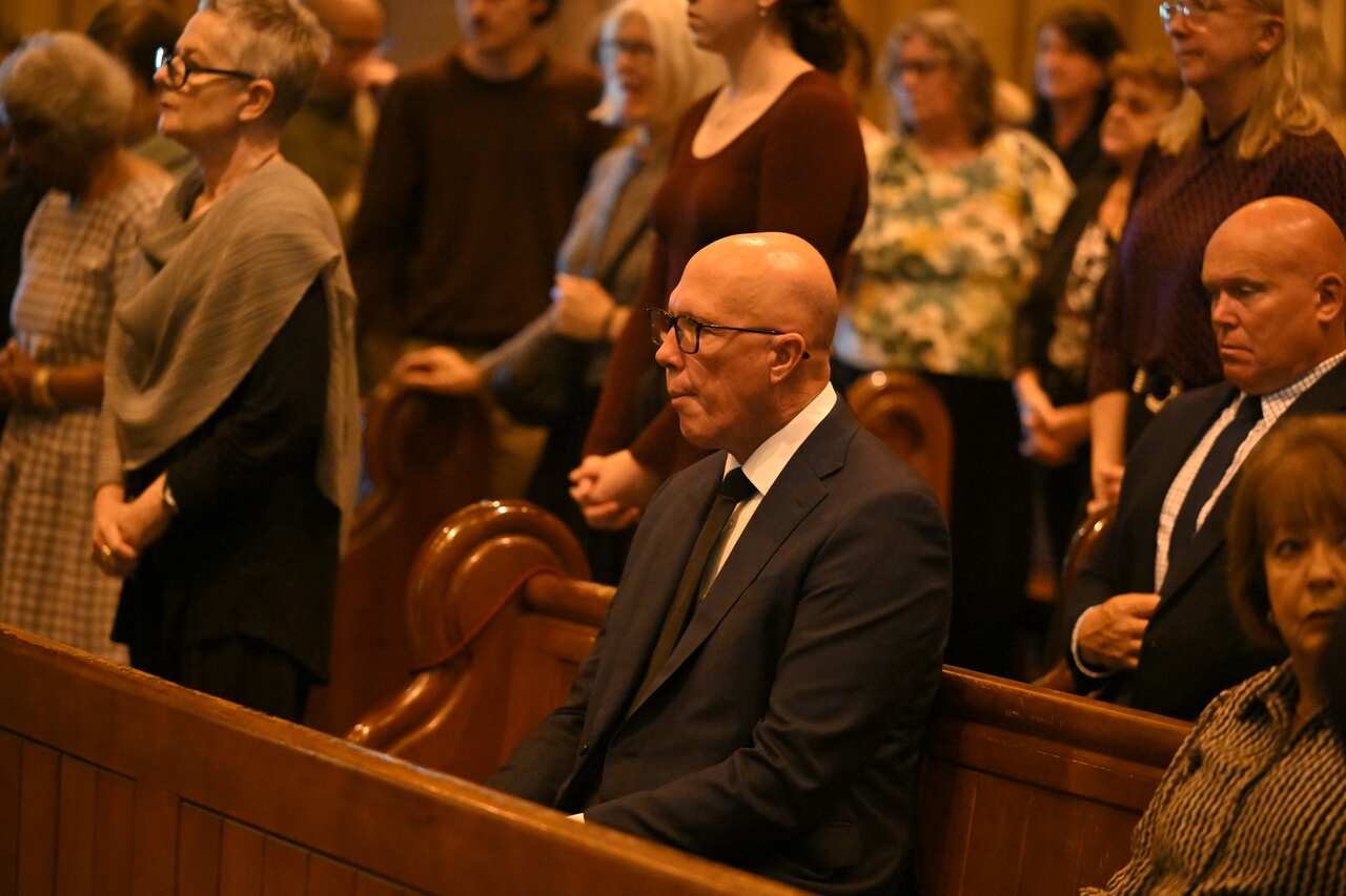 Peter Dutton sits in a church pew. 