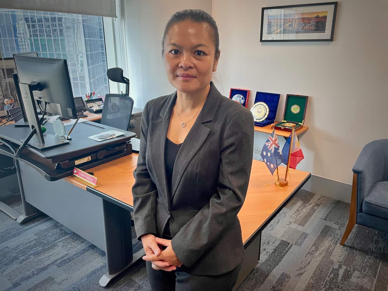 A woman in a suit, standing inside
