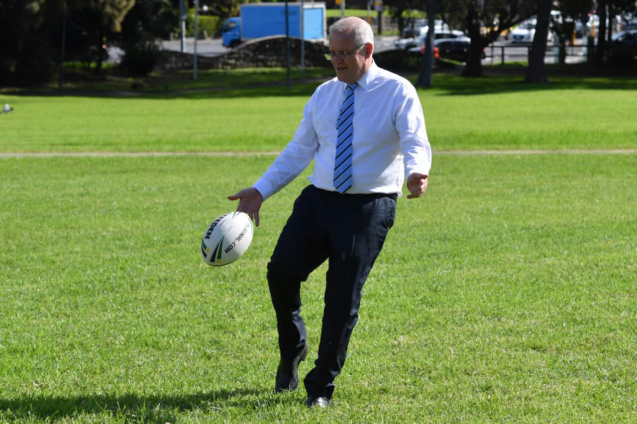 Man kicks a ball in a field. 