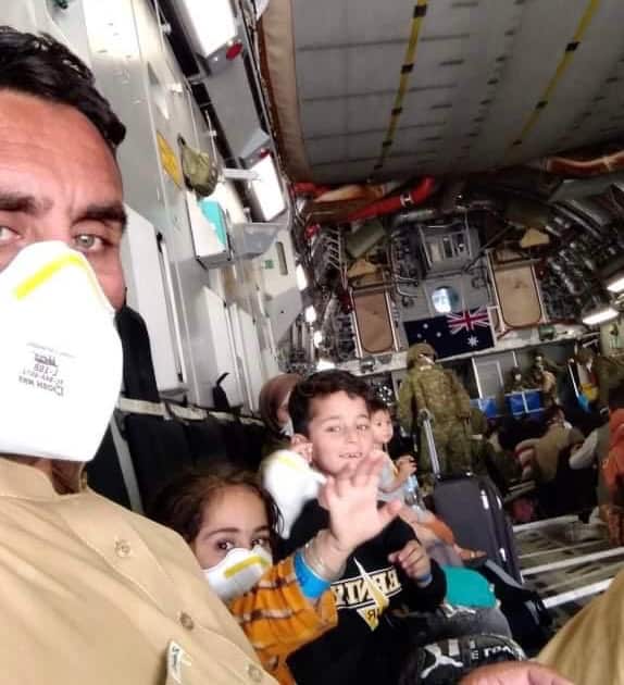 Sayed Wahdat Saddat (left) with his family members inside a Royal Australian Air Force Plane during the evacuation process from Afghanistan.