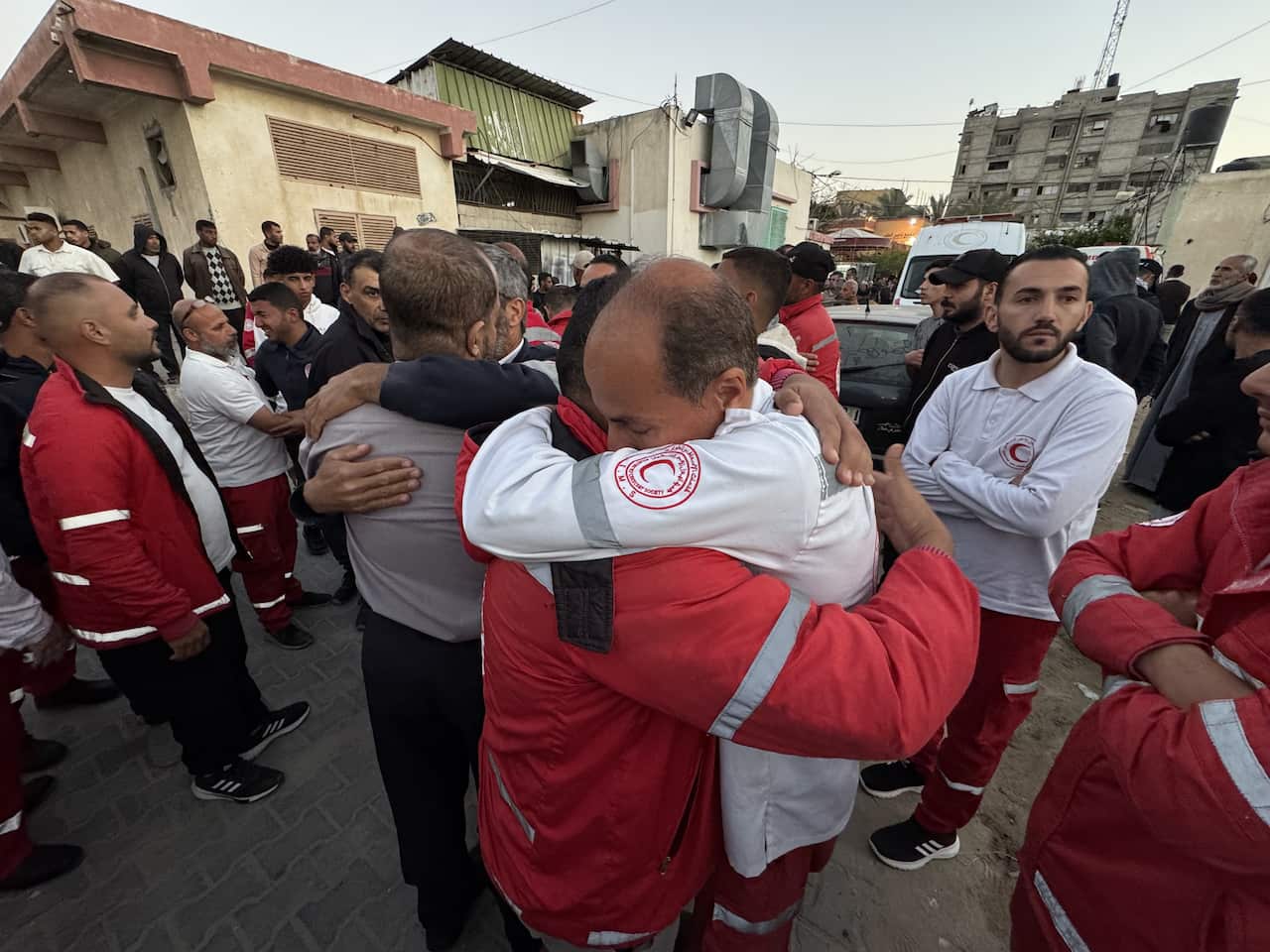 Two men in uniforms hug