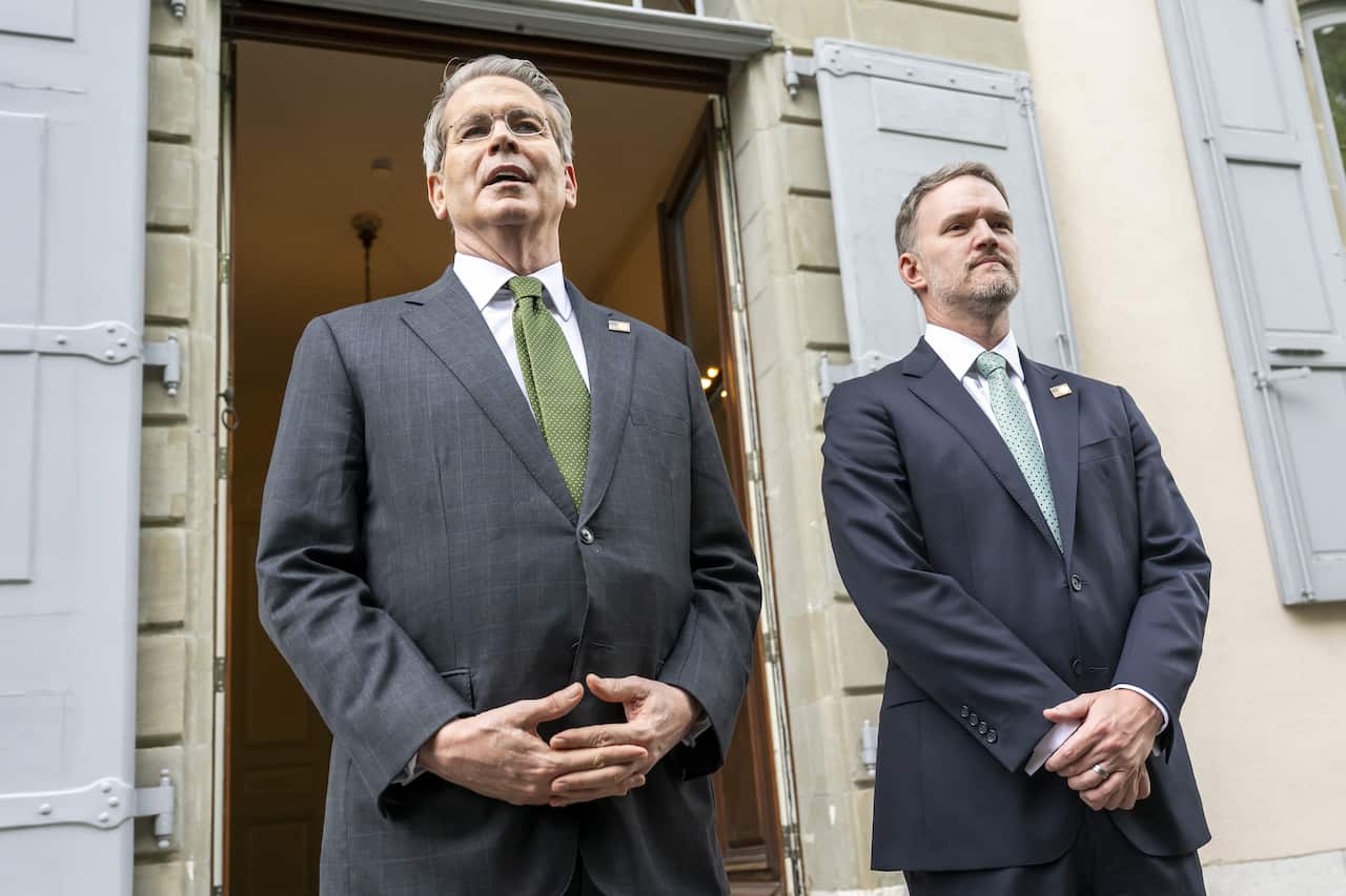 Two men wearing suits posing for a photograph