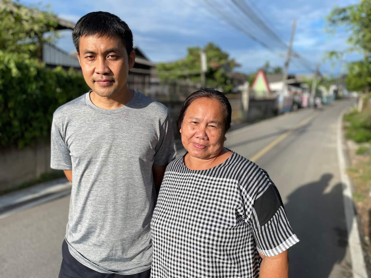A man and a woman standing on a quiet street.