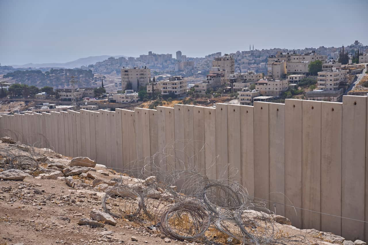 A long wall with buildings in the background