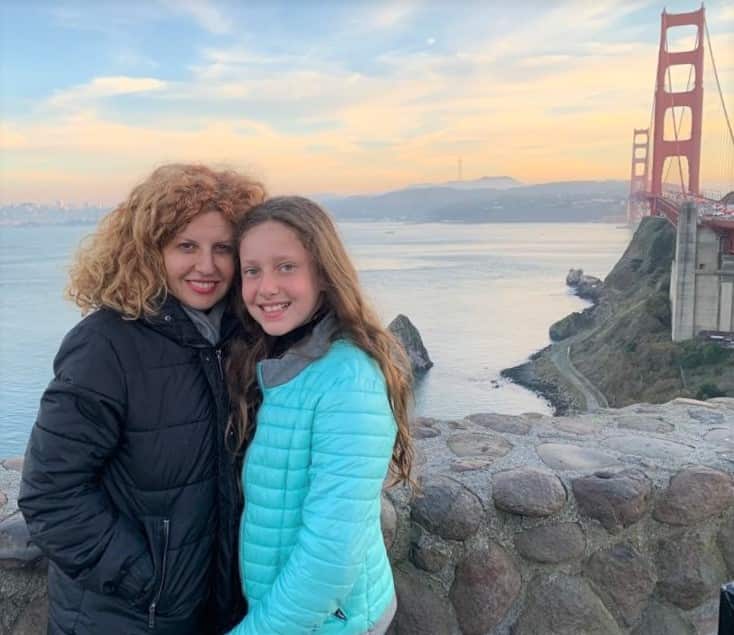 Bridget Sakr in a parka standing near water with her daughter Veronique.