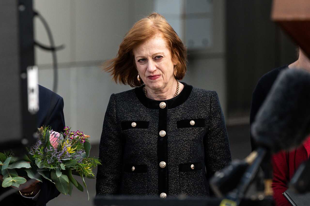 A woman wearing a black dress attends a commemoration ceremony. 