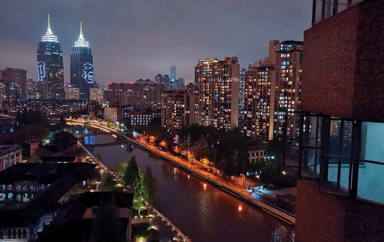 An evening light show is displayed on the twin towers of the landmark Global Harbor Shopping Mall in Shanghai.