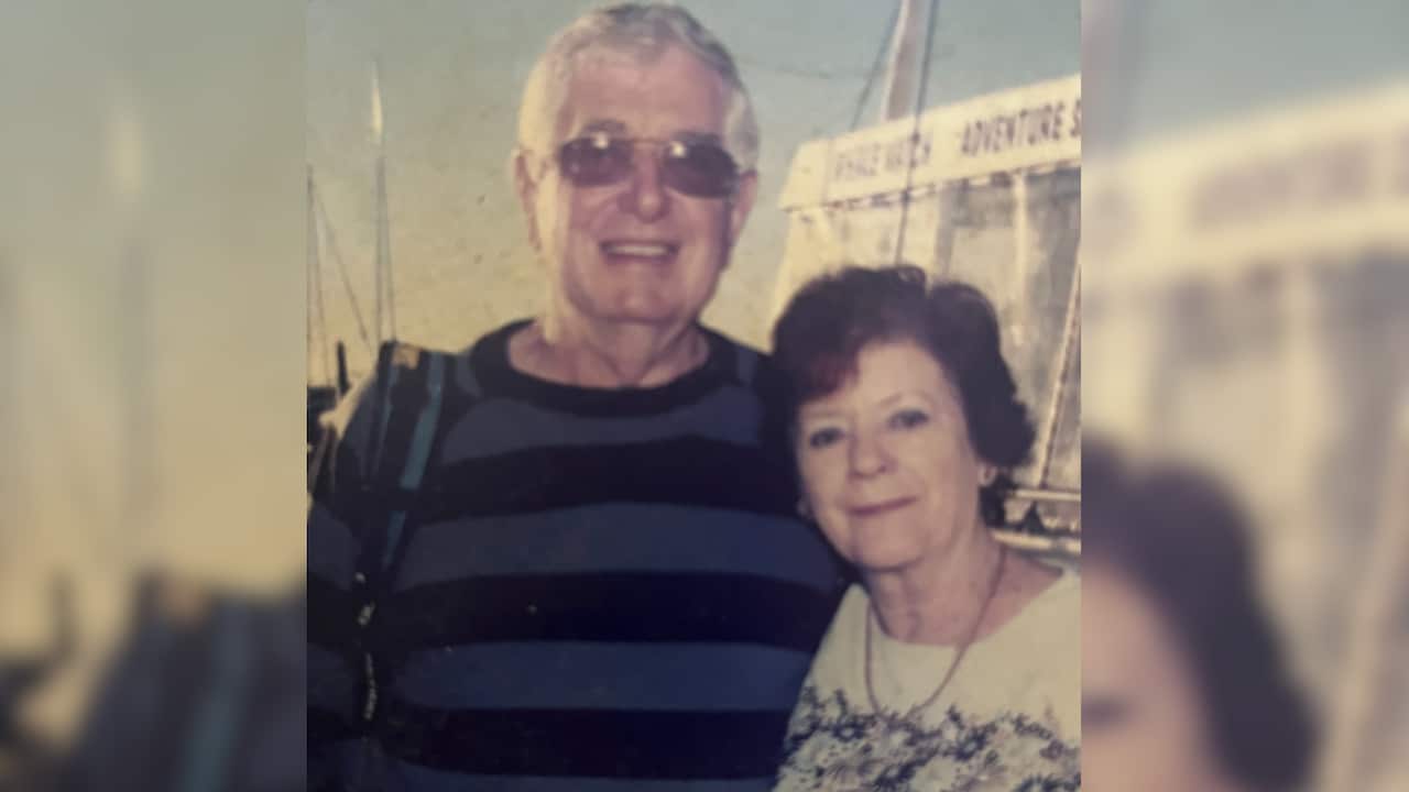 a grainy photo of a middle aged man in woman smiling together