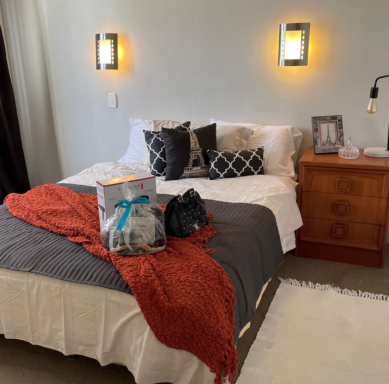 A furnished bedroom showing a bed and gifts 