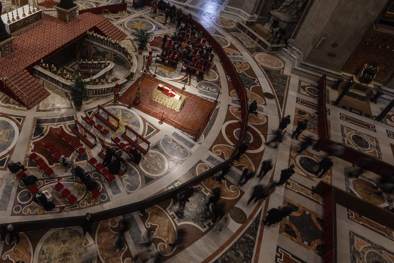 Pope Benedict XVI lay in state in the Vatican Basilica while people pay homage.