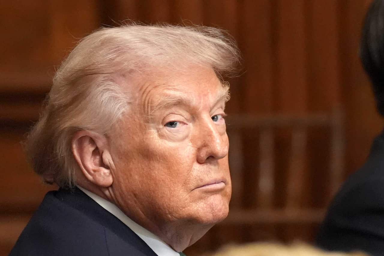 Donald Trump stares blankly over his right shoulder into the camera.