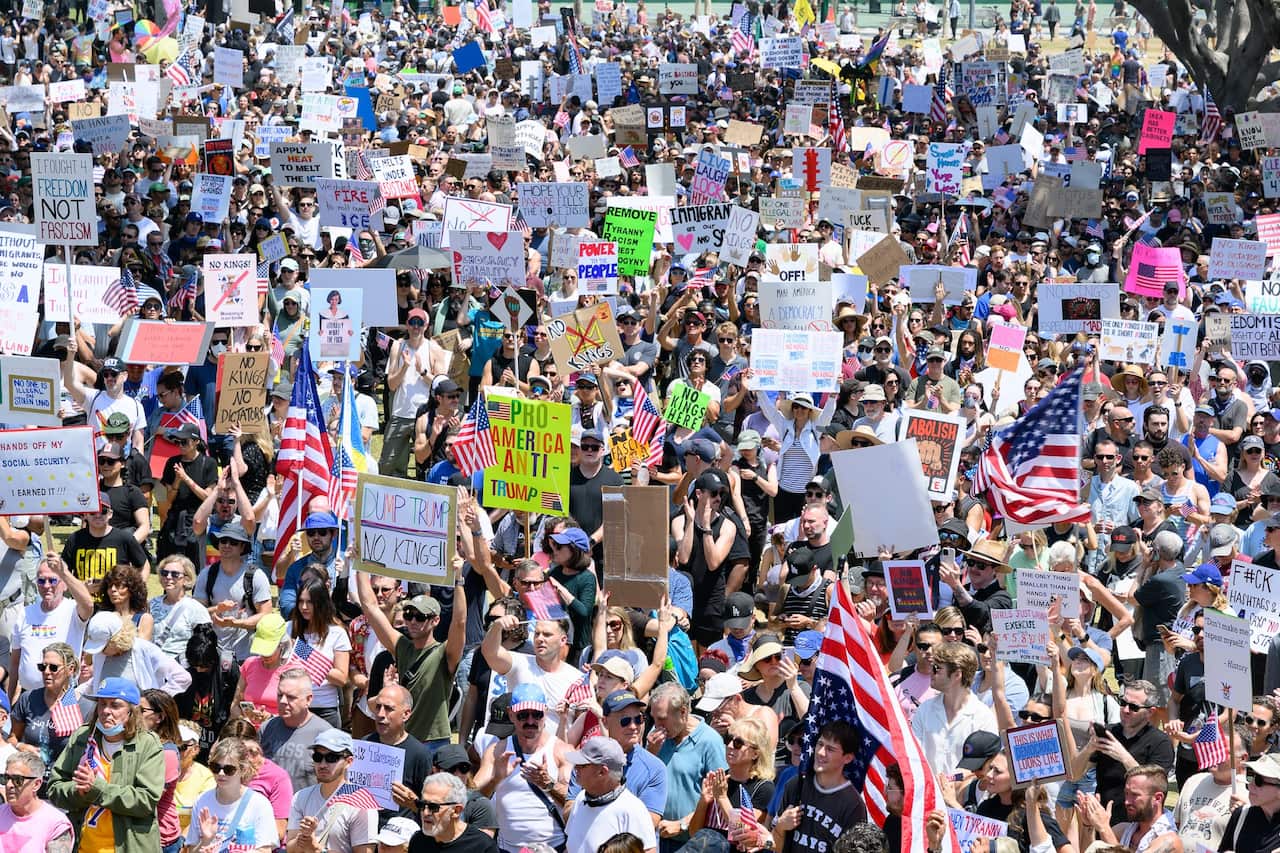 A wide shot of a group of protesters holding placards and flags.