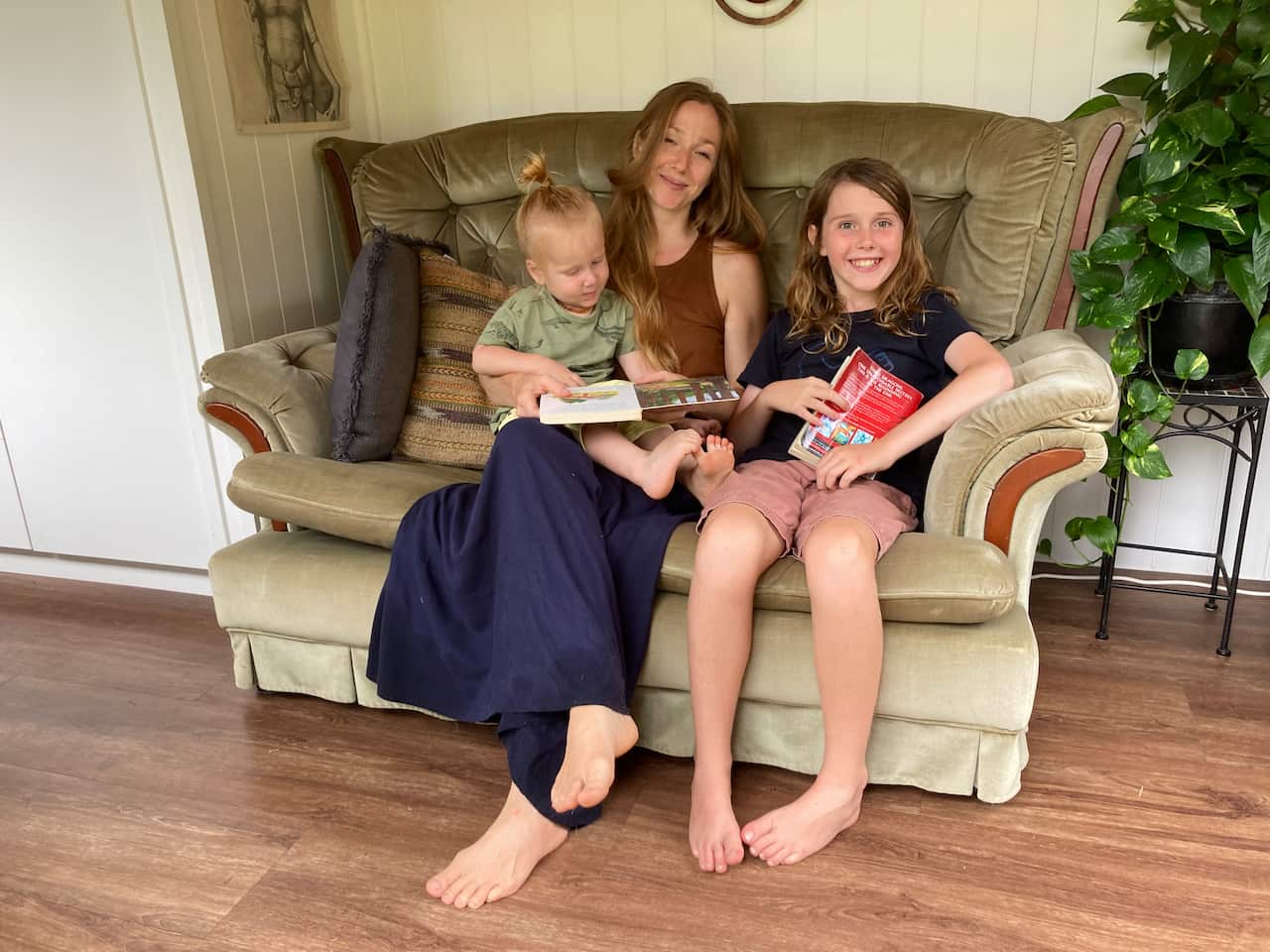 Angela and her sons Seb and Maliyan siting on a couch in a house