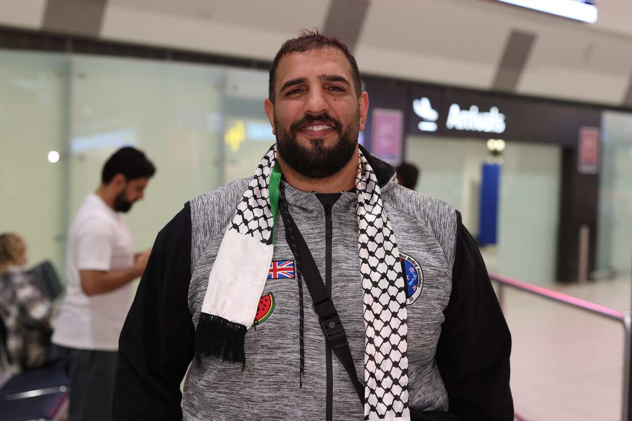 A man smiling while posing for a photo inside an airport.