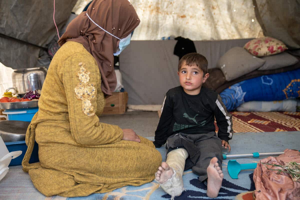 Jinderis, Syria - Abdulhamid , 7, was injured during the earthquake. Here sitting in a tent with a woman.