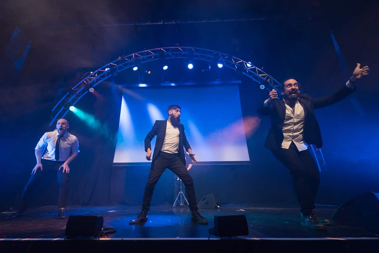 Three men performing on a stage