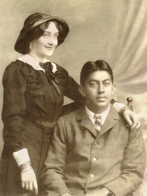 A white woman and Indian man pose for a portrait