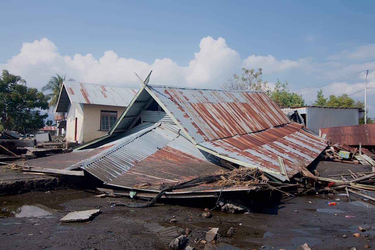 A collapsed house with only its roof visible.
