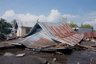 A collapsed house with only its roof visible.