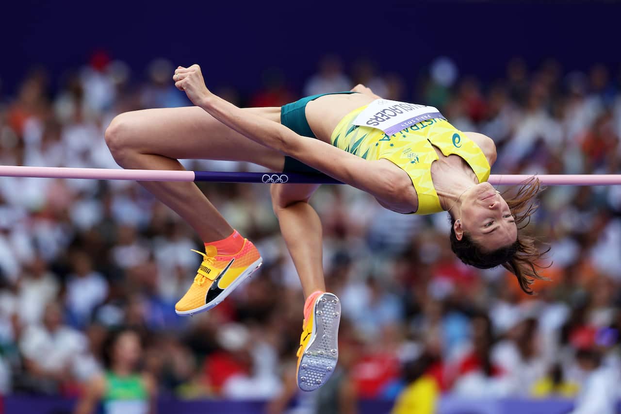 A woman jumps over a high jump bar 
