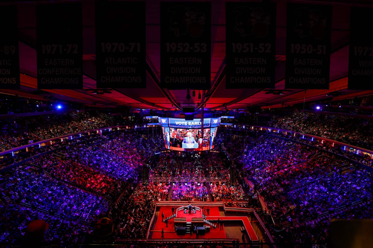 A stadium full of people bathed in blue and red lighting.