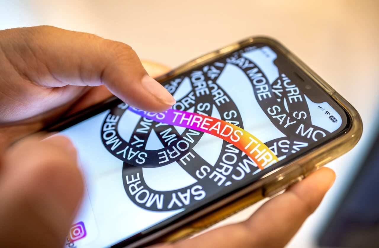 A person using the Theads app on a smartphone.