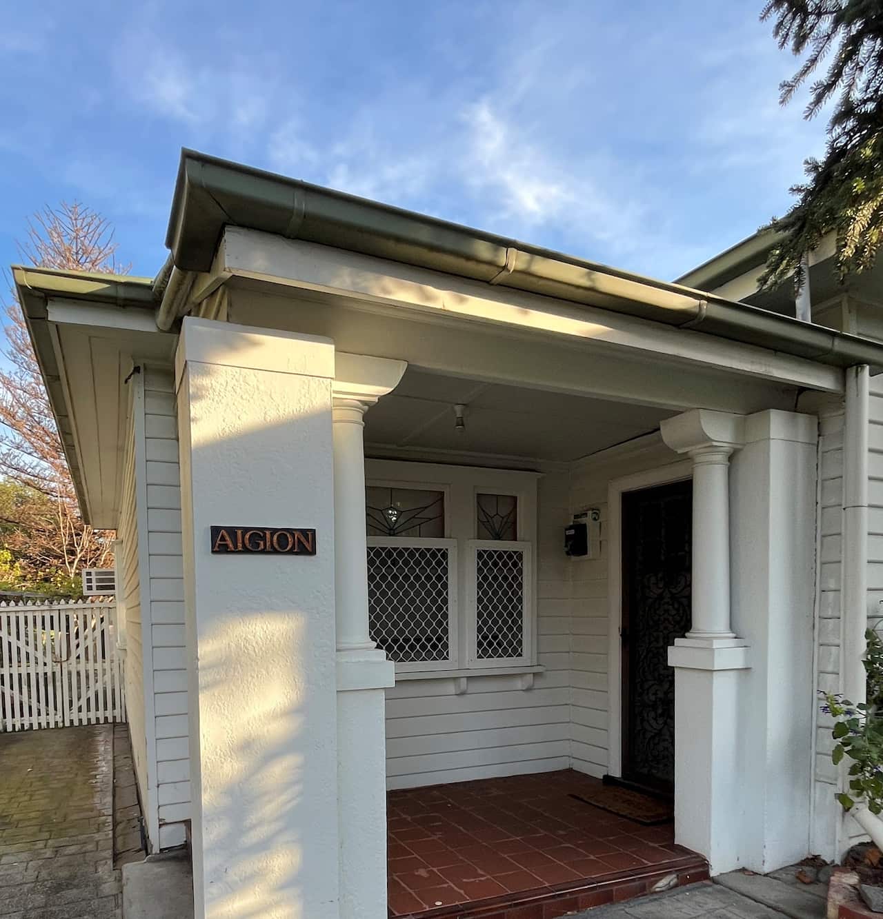 Η επιγραφή «AIGION» στο μπροστινό μέρος της κατοικίας της Ιωάννας Λιακάκου, δηλαδή το Αίγιο στη βόρεια Πελοπόννησο τόπος καταγωγής της ποιήτριας