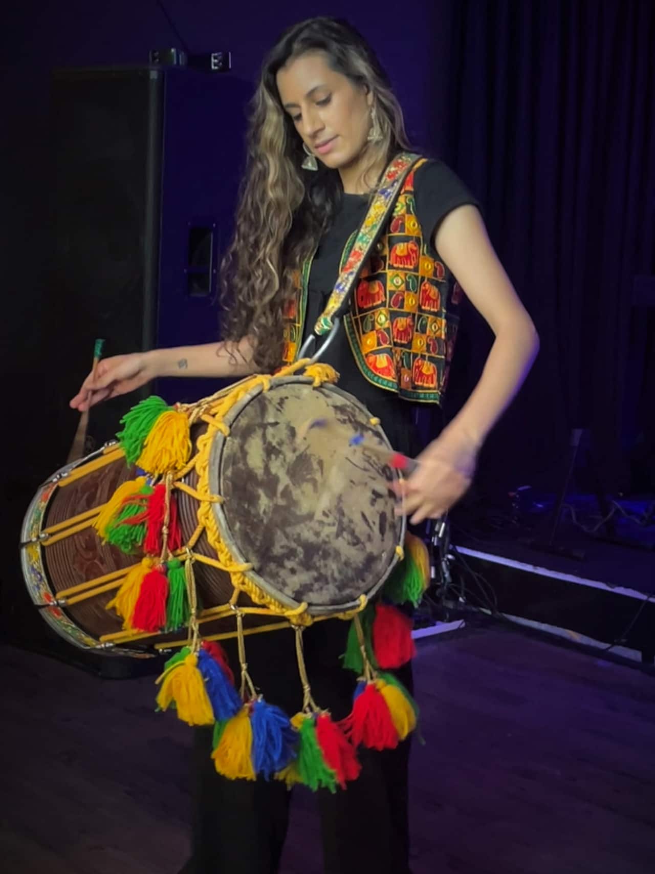 Priya holding her dhol and playing.