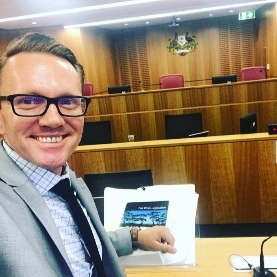 Danijel Malbasa smiles at the bar table at court. 