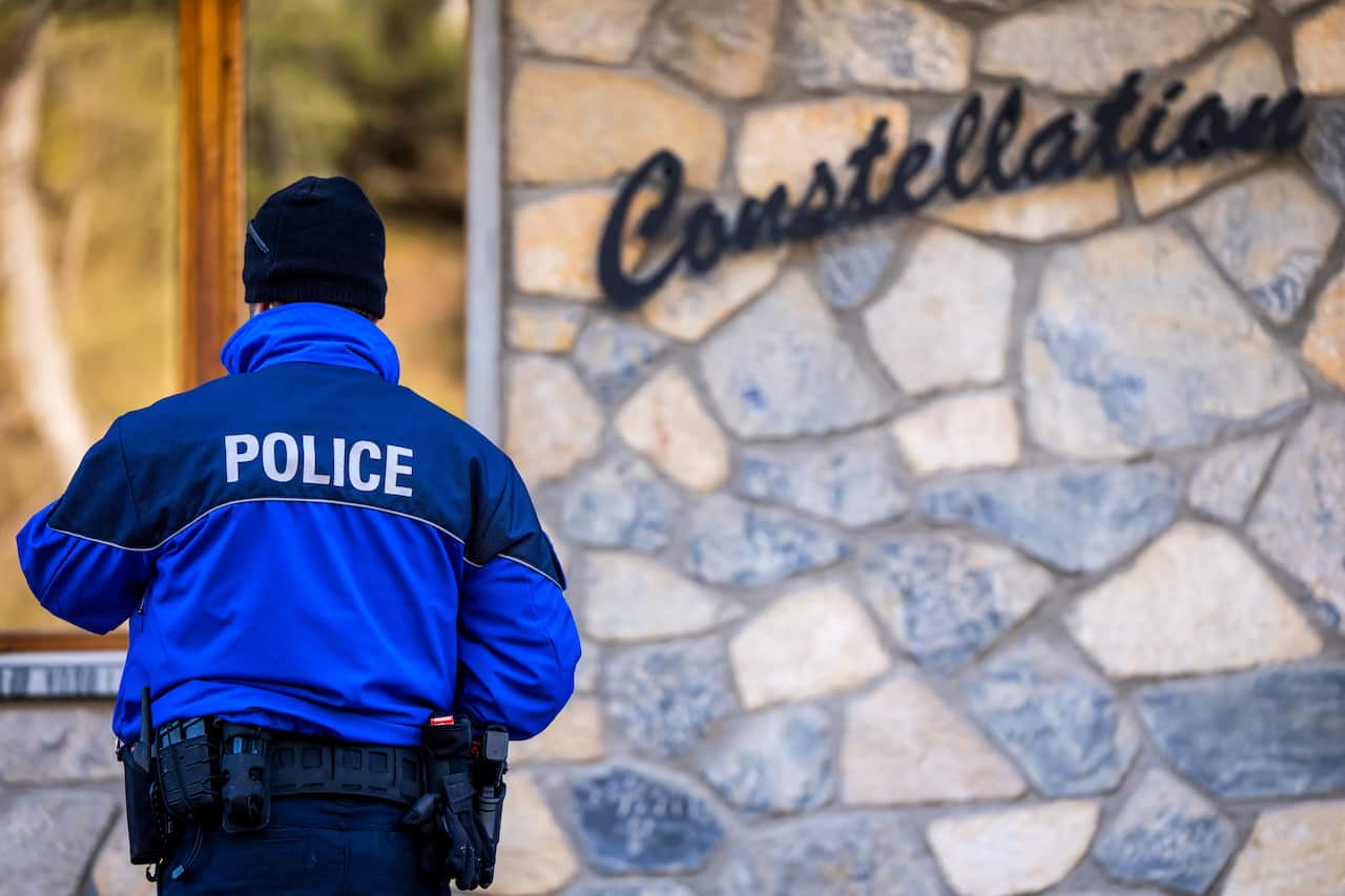 A police officer stands near the entrance of a building.