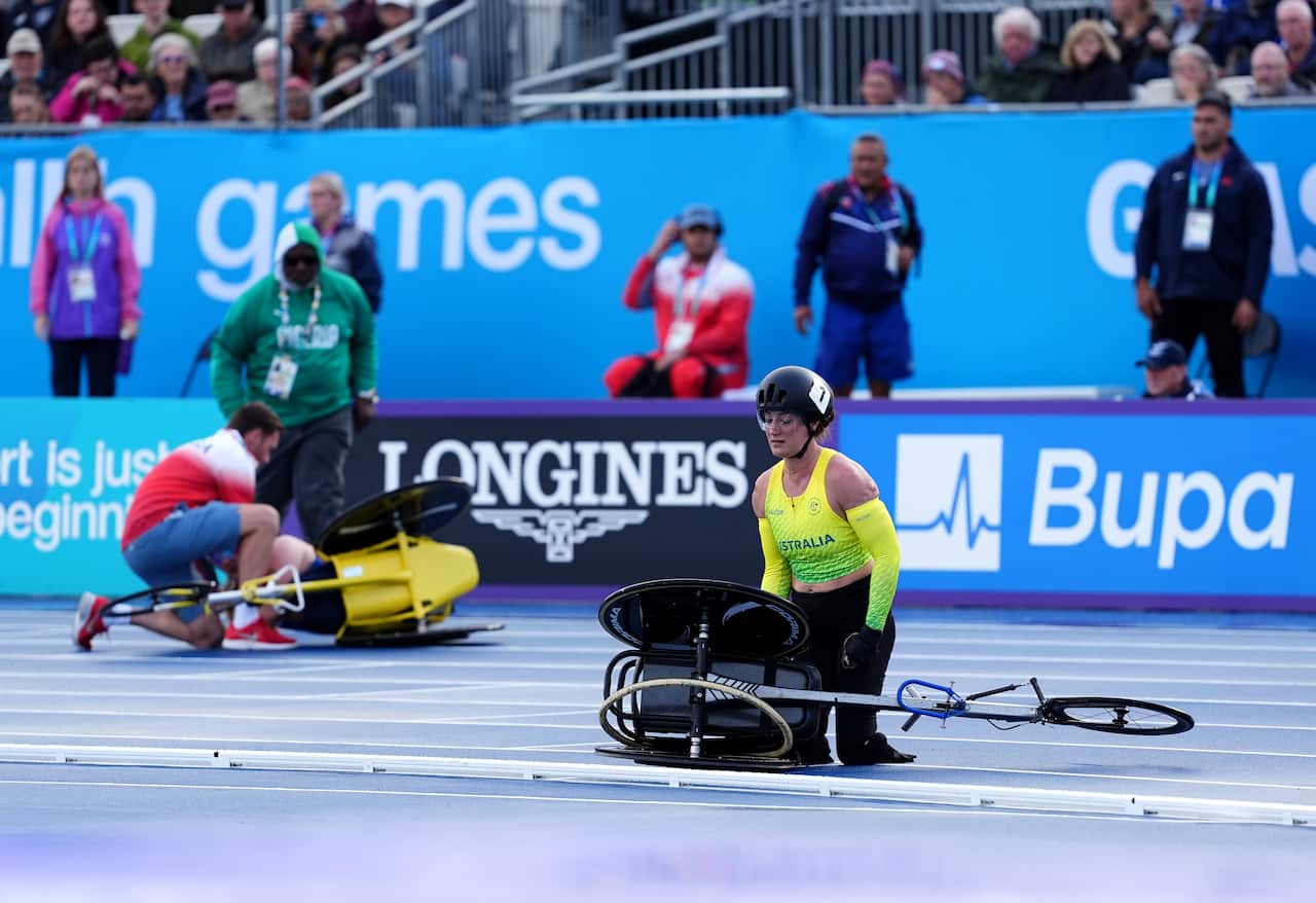 Two para-athletes on a track with their wheelchairs tipped to the side.