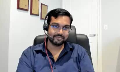 A man wearing glasses and a headset in a home office 