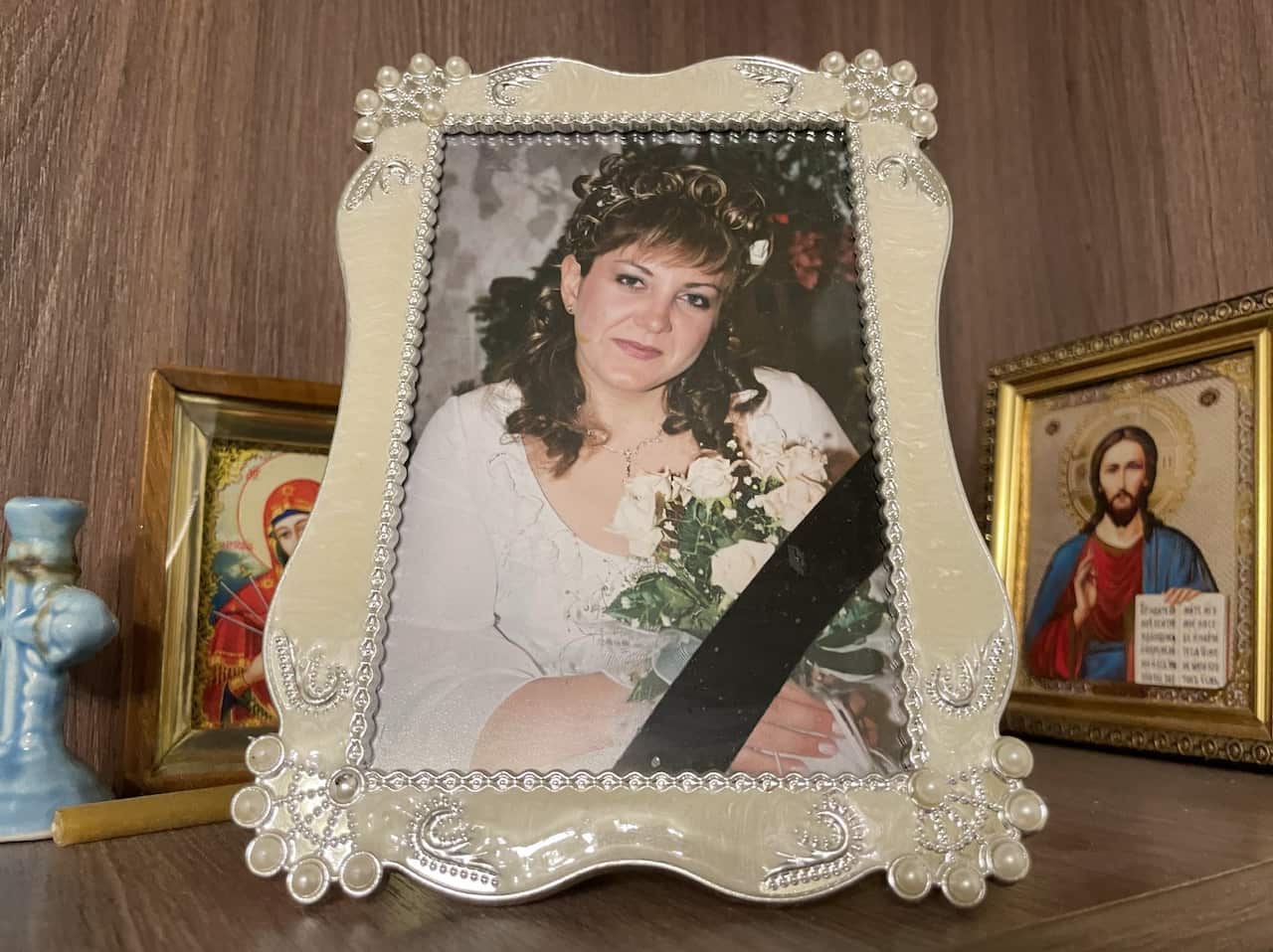 A photo frame holds an image of a woman.