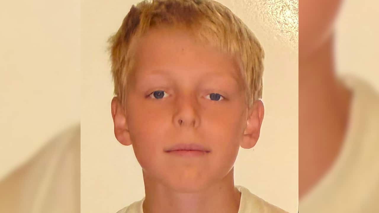 a closeup shot of a young blonde boy with a neutral expression