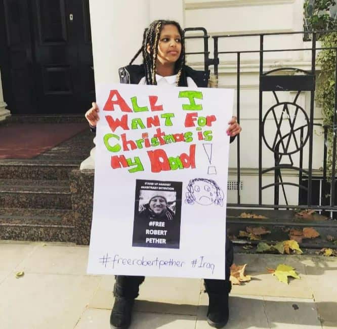 Young girl holding sign that says 'all I want for Christmas is my dad'