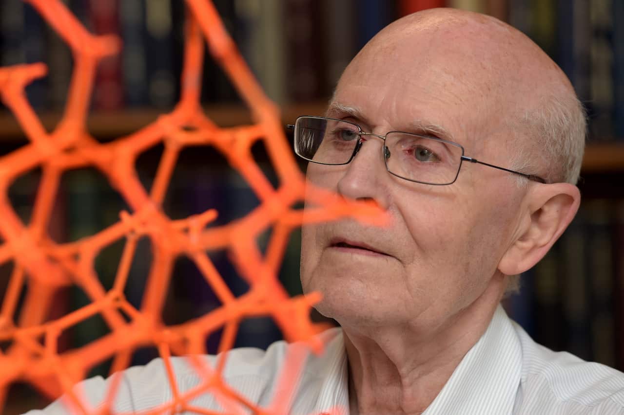 A man wearing glasses looks on