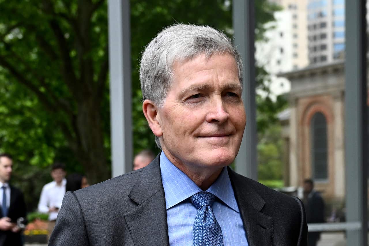 A man who is wearing a suit and tie standing outside.