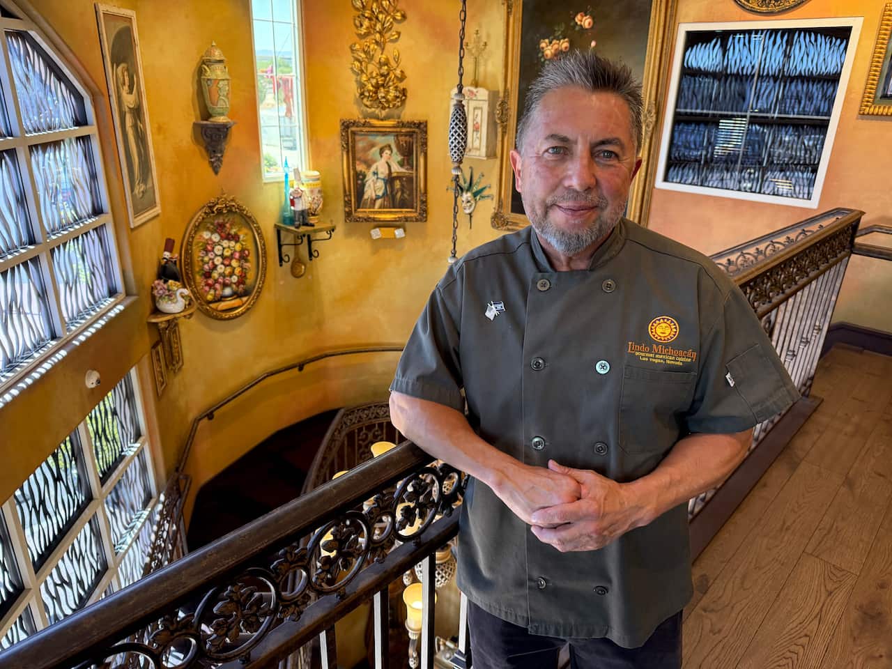 A man, who is also a restaurant owner, stands for a photo. 