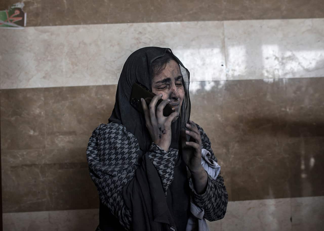 An injured woman speaking on the phone crying in a hospital
