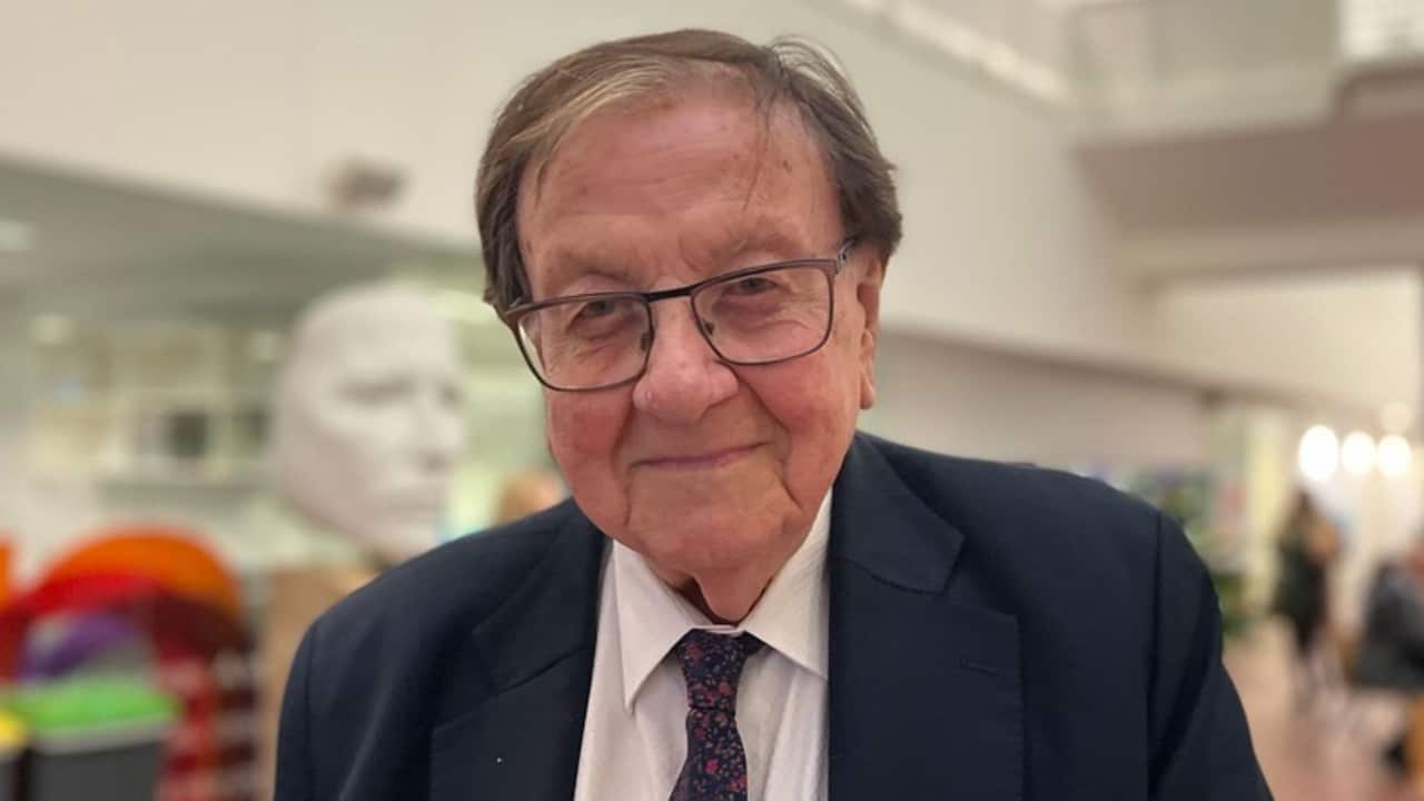 an older man with glasses and in a suit